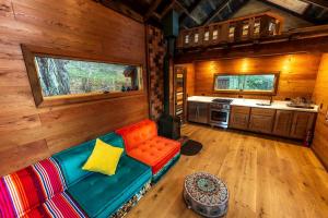 Una sala de estar con un sofá en una cabaña. en Half Moon Bay Glamping Getaway in an Idyllic Tree House and Cabin, en Half Moon Bay