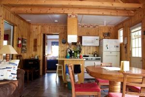 a kitchen with wooden walls and a table and a kitchen with a tablektop at Lakefront Cabin Rental with a Screened-In Porch near Pequot Lakes, Minnesota in Pine River