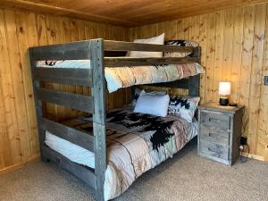 a bedroom with two bunk beds in a cabin at Scenic Vacation Home with Wrap-Around Deck Overlooking Ennis Lake near McAllister, Montana in Ennis