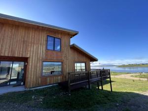 a wooden house with a bench in front of it at Scenic Vacation Home with Wrap-Around Deck Overlooking Ennis Lake near McAllister, Montana in Ennis