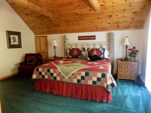 a bedroom with a bed and a wooden ceiling at Spacious Vacation Rental with a Stunning Stone Gas Fireplace in Fish Creek, Wisconsin in Fish Creek