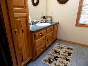 a bathroom with a sink and a black counter at Spacious Vacation Rental with a Stunning Stone Gas Fireplace in Fish Creek, Wisconsin in Fish Creek +9 photos