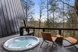 a hot tub on a deck with two chairs and a table at Intimate Private A-Frame with Spa and Beautiful Outdoor Living in Georgia in Lickskillet