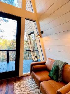 a living room with a couch and a large window at Intimate Private A-Frame with Spa and Beautiful Outdoor Living in Georgia in Lickskillet