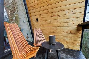 two chairs and a table with a hat on a patio at Intimate Private A-Frame with Spa and Beautiful Outdoor Living in Georgia in Lickskillet