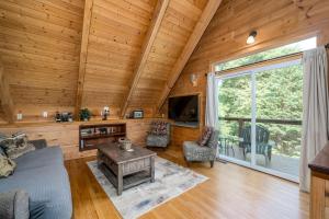 a living room with a couch and a tv in a cabin at Delightful Cabin Rental with Mountain Views near Chattahoochee National Forest, Georgia in Mineral Bluff
