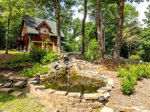 a garden with a pond in front of a house at Delightful Cabin Rental with Mountain Views near Chattahoochee National Forest, Georgia in Mineral Bluff +53 photos