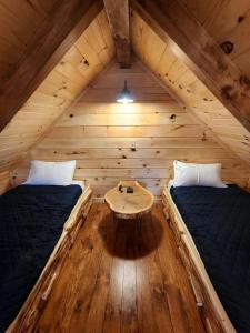 una camera con due letti e un tavolo in una cabina di Pet-Friendly Tree Cabin by Tappan Lake with Lofted Space in Ohio 