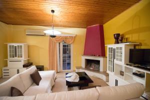 sala de estar con sofá blanco y chimenea en Magician's Apartments, en Lefkada