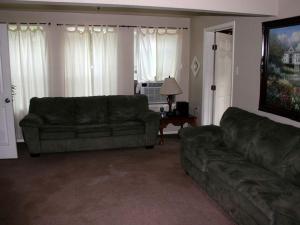 ein Wohnzimmer mit Sofa und Tisch in der Unterkunft Spacious 10-Person Cabin Rental on Lake Dunlap near Austin, Texas in Schumannsville