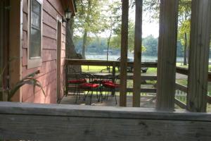 a porch of a house with chairs and a table at Spacious 10-Person Cabin Rental on Lake Dunlap near Austin, Texas in Schumannsville