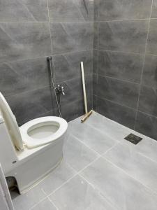 a bathroom with a white toilet in a room at Durrani House in Dargai