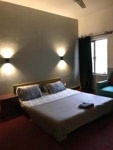 a bedroom with a bed with two pillows and a window at Durrani House in Dargai
