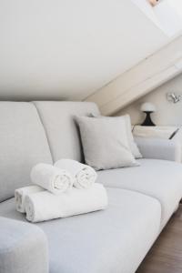 two rolled towels sitting on a white couch at Studio sous les toits Annecy Centre-Ville in Annecy
