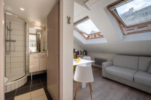 a bathroom with a couch and a table in a room at Studio sous les toits Annecy Centre-Ville in Annecy