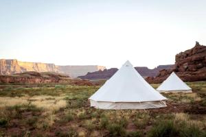 zwei Zelte auf einem Feld mit Felsen im Hintergrund in der Unterkunft Unique Secluded Glamping Tent with Spectacular Canyon and River Views in Moab, Utah in Allen Memorial Hospital Heliport + 24 Fotos