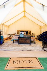a marquee with a welcome mat in a tent at Scenic Northern Michigan Glamping Tent on a Regenerative Farm in Elmira