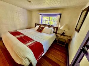 une chambre avec un grand lit et une fenêtre dans l'établissement Artistic Garden Casita on Organic Farm in New Mexico, à San Cristobal