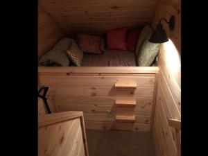 a small room with a bed in a wooden cabin at Pristine and Cozy Cabin Rental Overlooking Pond near Rochester, New York in Naples