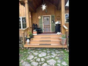 a house with a wooden staircase leading to the front door at Pristine and Cozy Cabin Rental Overlooking Pond near Rochester, New York in Naples