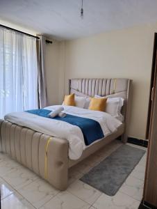 une chambre avec un grand lit avec des oreillers jaunes dans l'établissement Nakuru modern home, à Nakuru 11 autres photos