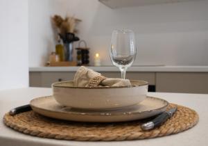 a bowl on a plate with a glass of wine at La Suite Asmée - Centre-ville Lons-le-Saunier in Lons-le-Saunier
