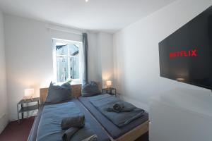 a bedroom with a bed with a tv on the wall at Urbanes Dachrefugium mit Balkon in Königs Wusterhausen