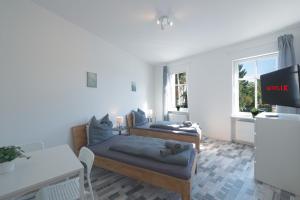 a living room with two beds and a tv at Urbanes Dachrefugium mit Balkon in Königs Wusterhausen