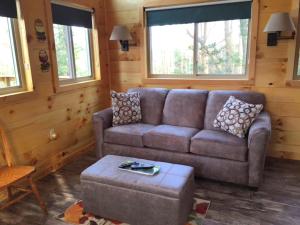 a living room with a couch and a table at Breathtaking Tree House Rental near Charleston, West Virginia in Hico