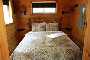 a bedroom with a bed with a table on it at Breathtaking Tree House Rental near Charleston, West Virginia in Hico