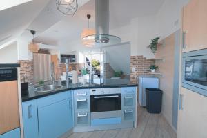 a kitchen with blue cabinets and a sink at Urbanes Dachrefugium mit Balkon in Königs Wusterhausen