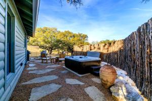 a backyard with a hot tub and a fence at Pet-Friendly Glamping Cabin, with River Access in Ingram, Texas in Hunt
