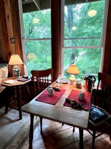 AvonにあるCharming Vacation Rental in a Barn on a Horse Farm near Afton Mountain in Virginiaの大きな窓のある部屋(木製テーブル付)
