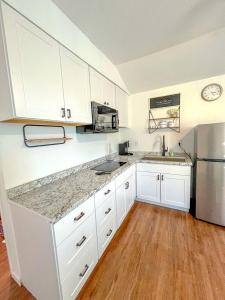 a kitchen with white cabinets and a refrigerator at Cozy Tiny House Ideal for a Couples Retreat in Lake Hills, Texas in Lakehills