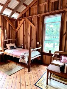 AvonにあるCharming Vacation Rental in a Barn on a Horse Farm near Afton Mountain in Virginiaの木製の部屋にベッド1台が備わるベッドルーム1室があります。