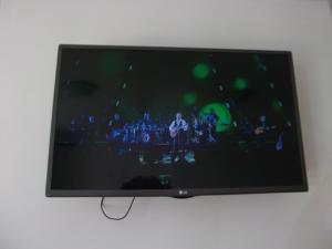 een flatscreen-tv die aan de muur hangt bij Deima in Nida