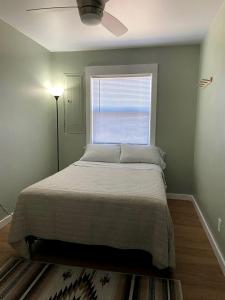 a bedroom with a large bed with a window at Secluded Modern Vacation Home with Madison Range Views near Ennis Lake, McAllister Montana in Ennis