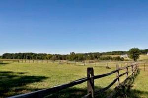 a wooden fence in the middle of a field at Pleasant Cozy Airstream with Amazing Stargaze and Farm Views in Maryland in Seneca Highlands +26 photos