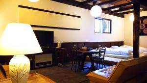 un soggiorno con letto, tavolo e sedie di Rickshaw inn a Takayama
