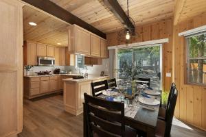 大贝尔城Spacious Modern Cabin Near Big Bear Lake in California的一间带桌椅的厨房和一间用餐室