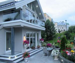a house with a balcony with a table and flowers at Villa Baneheia in Kristiansand