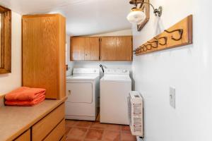 a kitchen with a refrigerator and a washer and dryer at Cozy Off-Grid Cabin with Equipped Outdoor Deck and Picnic Space in Utah in Monticello +54 photos