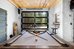 une table de billard dans une pièce avec une fenêtre dans l'établissement Amazing Secluded Cabin Perfect for Couples in Broken Bow, Oklahoma, à Stephens Gap