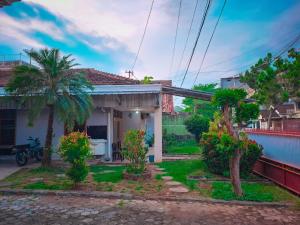 a small house with a palm tree in the yard at MAWAR Guest House By Hans Management in Bandar Lampung