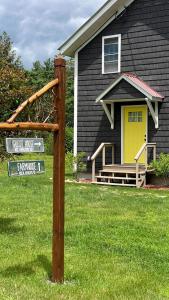 a house with a yellow door and a street sign at Beautiful Wells Rental Family Vacation in New York in Wells
