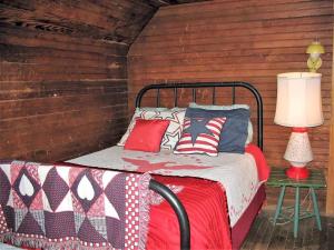 ein Schlafzimmer mit einem Bett mit einer rot-weißen Decke in der Unterkunft Secluded Family-Friendly Cabin Rental on 90 Acres in Newland, North Carolina in Newland