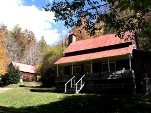 ein Haus mit einem roten Dach und einer Scheune in der Unterkunft Secluded Family-Friendly Cabin Rental on 90 Acres in Newland, North Carolina in Newland
