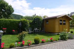 a small yellow shed in a yard with flowers at Haus Reitz in Ernst