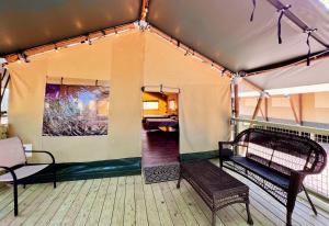 a porch with two benches in a tent at Lovely Safari Tent with River Access, Fire Pit and Barbecue in Staples, Texas in Staples