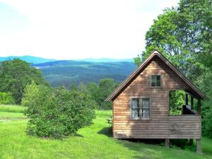 a small house in the middle of a field at Rustic Vacation Rental on a Beautiful Working Farm in Royalton, Vermont in South Royalton